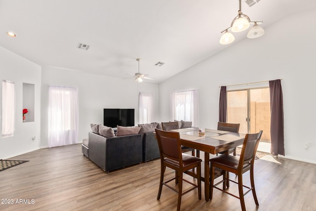 dining area featuring ceiling fan, wood-type flooring, and lofted ceiling