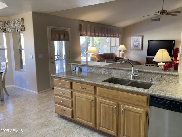 kitchen featuring sink, vaulted ceiling, stainless steel dishwasher, and light stone countertops