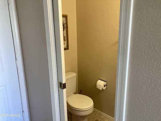 bathroom with tile patterned flooring and toilet