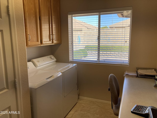 laundry room featuring washer and dryer, light tile patterned floors, and cabinets