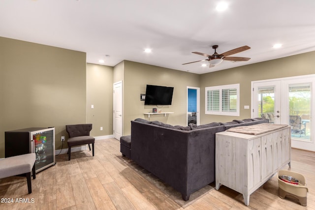 living room with ceiling fan, light hardwood / wood-style floors, and french doors