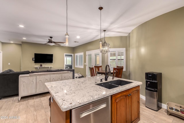 kitchen featuring dishwasher, sink, an island with sink, and ceiling fan with notable chandelier