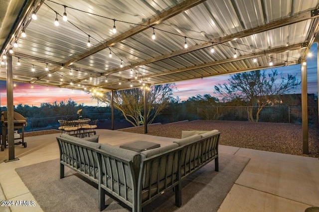 patio terrace at dusk with an outdoor living space and area for grilling