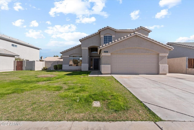 mediterranean / spanish-style home featuring a garage and a front lawn