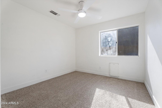 carpeted spare room with ceiling fan