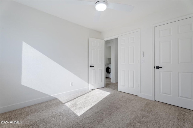 unfurnished bedroom featuring ceiling fan, light colored carpet, and washer / dryer