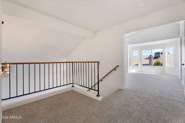 hallway featuring carpet and vaulted ceiling with beams