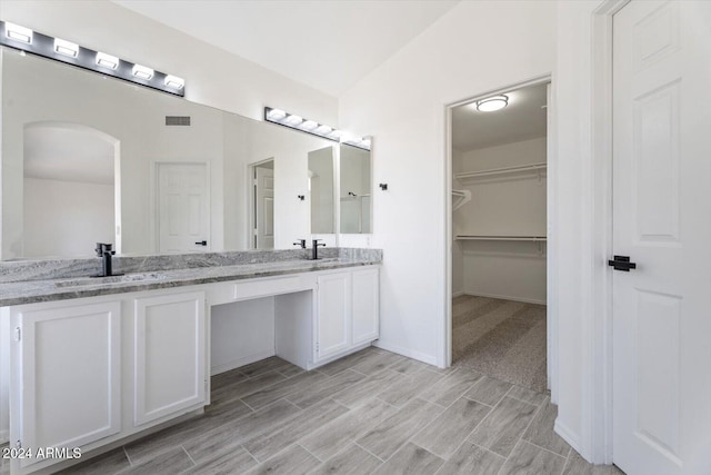 bathroom with vanity and vaulted ceiling