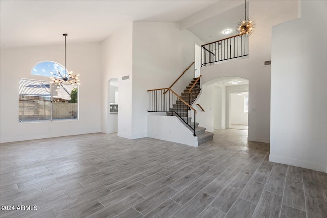 unfurnished living room featuring a chandelier, wood-type flooring, high vaulted ceiling, and beamed ceiling