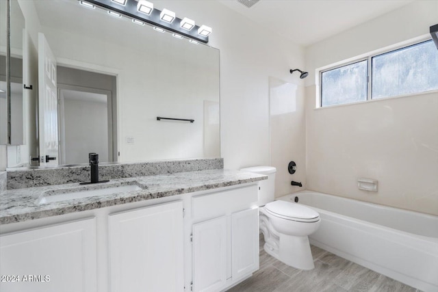 full bathroom featuring hardwood / wood-style floors, vanity, bathtub / shower combination, and toilet