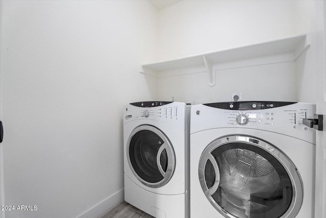 laundry room featuring hardwood / wood-style floors and washing machine and clothes dryer