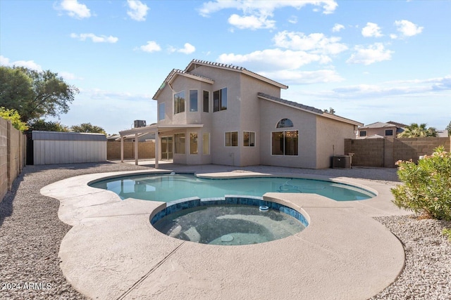 view of pool with an in ground hot tub, a shed, central AC unit, and a patio area