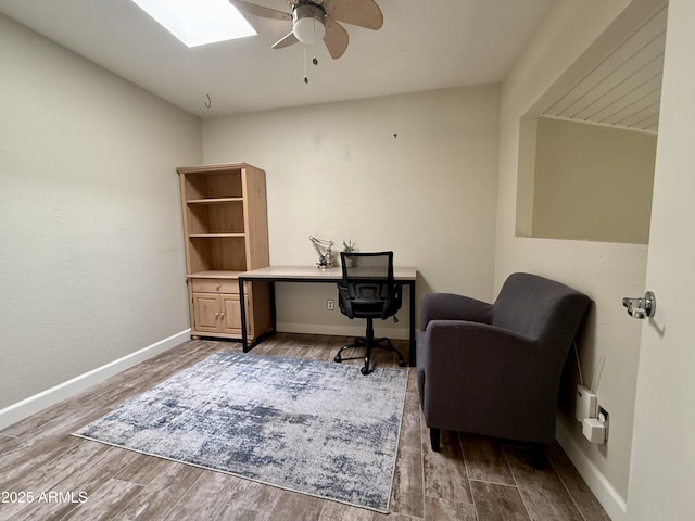 office area with ceiling fan, a skylight, and wood-type flooring