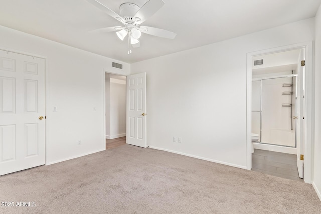 unfurnished bedroom featuring baseboards, carpet flooring, visible vents, and ensuite bath