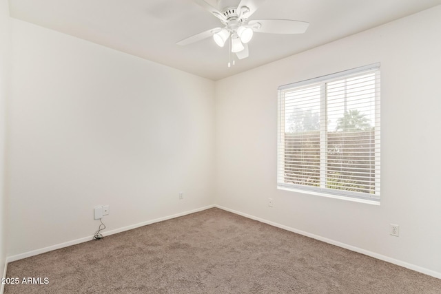 carpeted empty room with ceiling fan and baseboards