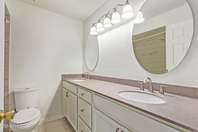 bathroom with double vanity, a sink, toilet, and tile patterned floors