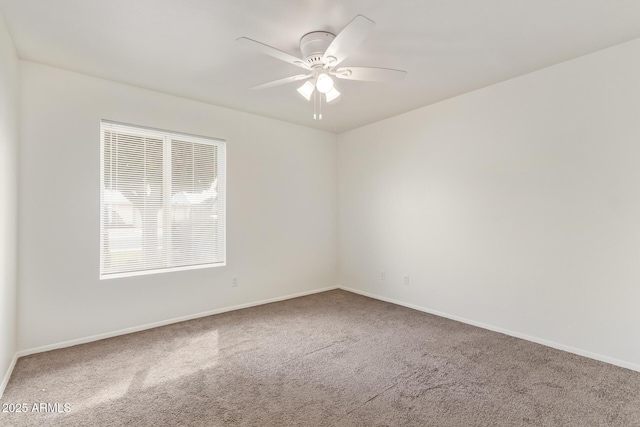 empty room with a ceiling fan, carpet flooring, and baseboards