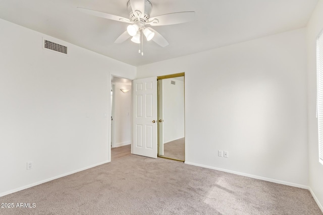 spare room featuring carpet, visible vents, ceiling fan, and baseboards