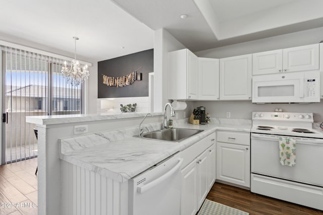 kitchen with a sink, white appliances, dark wood-style floors, and white cabinetry