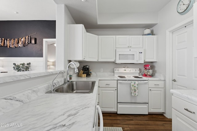 kitchen featuring dark wood finished floors, white appliances, white cabinets, and a sink