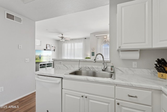 kitchen with visible vents, white dishwasher, dark wood-style floors, white cabinets, and a sink