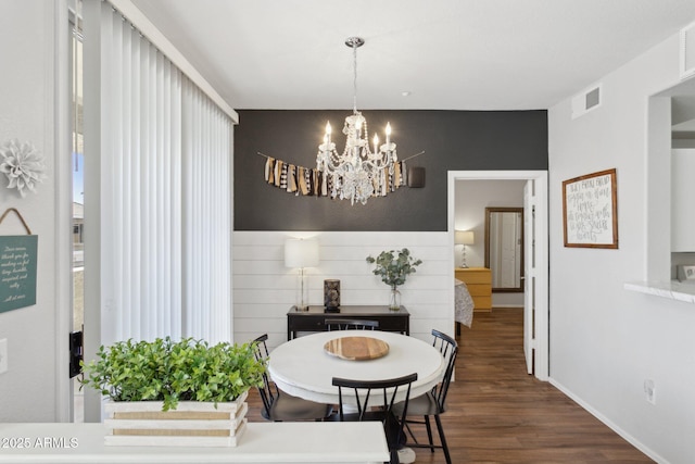 dining area featuring dark wood finished floors, visible vents, and a chandelier