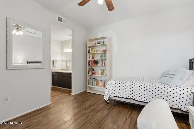 bedroom featuring a ceiling fan, wood finished floors, visible vents, baseboards, and ensuite bathroom