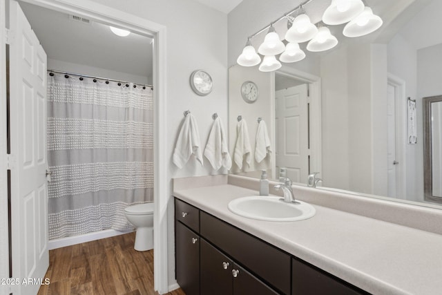 bathroom with vanity, a shower with shower curtain, wood finished floors, visible vents, and toilet