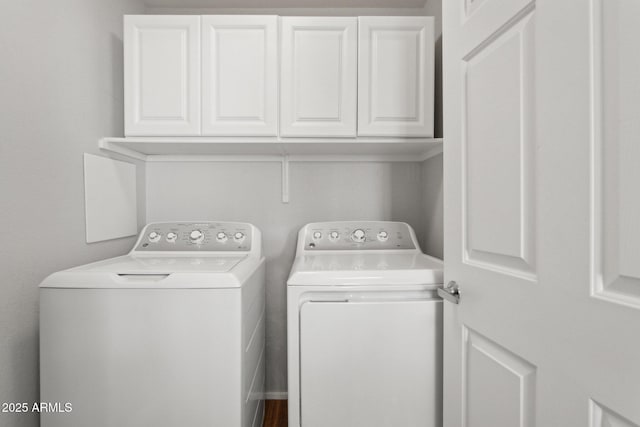 clothes washing area featuring cabinet space and washer and dryer