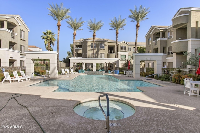 pool featuring a patio area, fence, and a hot tub