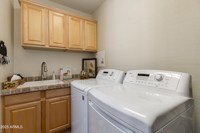 washroom featuring cabinets, washing machine and dryer, and sink