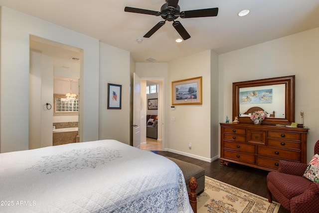 bedroom featuring ensuite bath, dark wood-type flooring, and ceiling fan