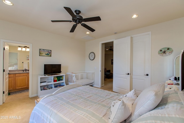 carpeted bedroom featuring ensuite bathroom and ceiling fan