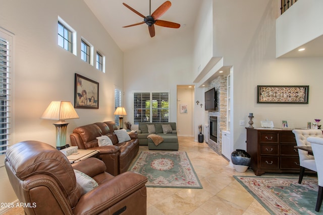 living room featuring high vaulted ceiling, a stone fireplace, a wealth of natural light, and ceiling fan