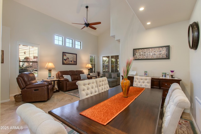 dining room featuring light tile patterned flooring, a towering ceiling, and ceiling fan