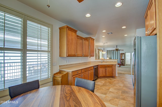 kitchen with decorative light fixtures, stainless steel appliances, sink, kitchen peninsula, and ceiling fan