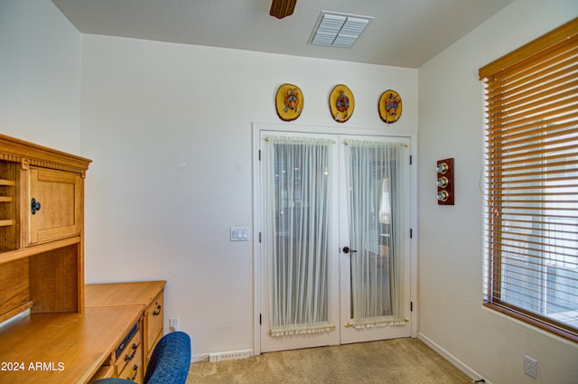 carpeted office space featuring ceiling fan