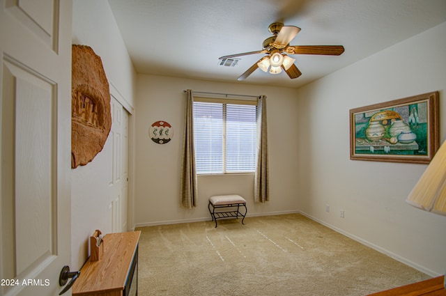 living area with ceiling fan and light carpet