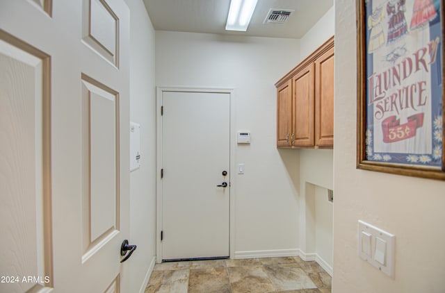 laundry area featuring cabinets