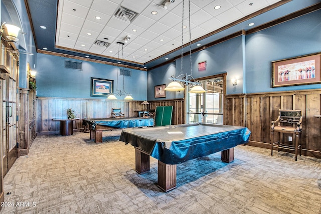 rec room with billiards, a tray ceiling, crown molding, light colored carpet, and a high ceiling