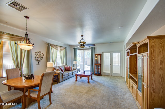 living room featuring a textured ceiling, light carpet, and french doors