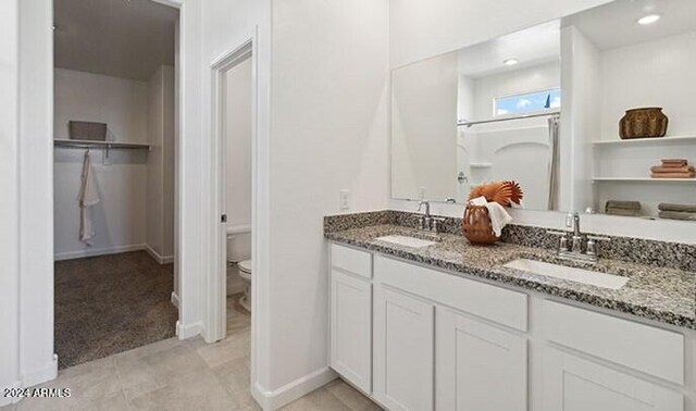 1336 W Hess Ave, Coolidge, AZ 85128 - bathroom featuring toilet, double vanity, and a spacious closet