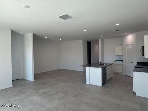 1336 W Hess Ave, Coolidge, AZ 85128 - kitchen featuring dark countertops, open floor plan, a sink, recessed lighting, and white cabinets