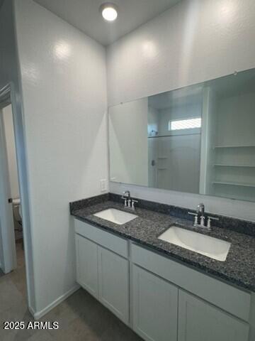 1336 W Hess Ave, Coolidge, AZ 85128 - full bathroom featuring double vanity, toilet, and baseboards