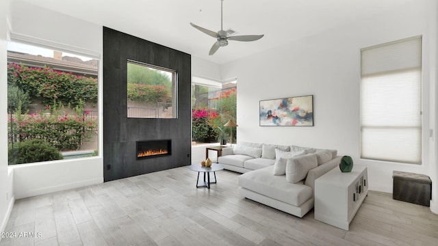 living room featuring a wealth of natural light, a fireplace, and light wood-type flooring