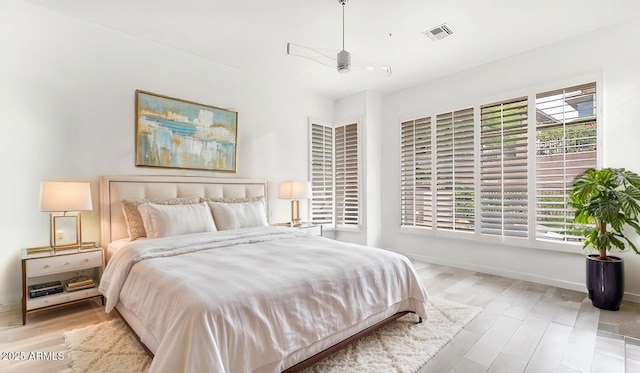 bedroom featuring visible vents, baseboards, and wood finished floors