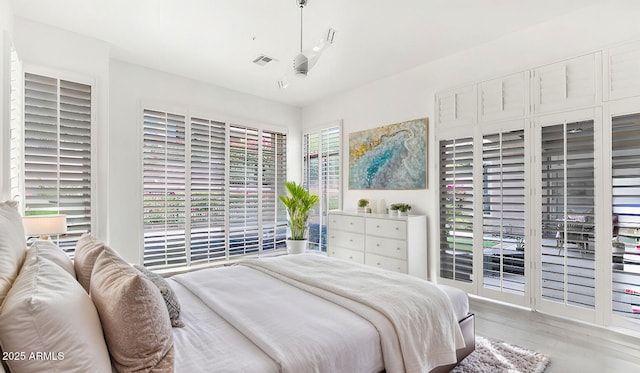 bedroom featuring wood finished floors and visible vents