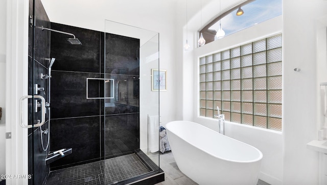 full bath featuring a stall shower and a freestanding tub