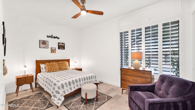 bedroom with ceiling fan, baseboards, and wood finished floors