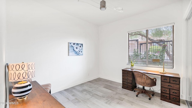 office area featuring baseboards and light wood finished floors